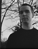 Black and white image of typeface designer Jess Latham with a grey sky and bare tree branches in the background